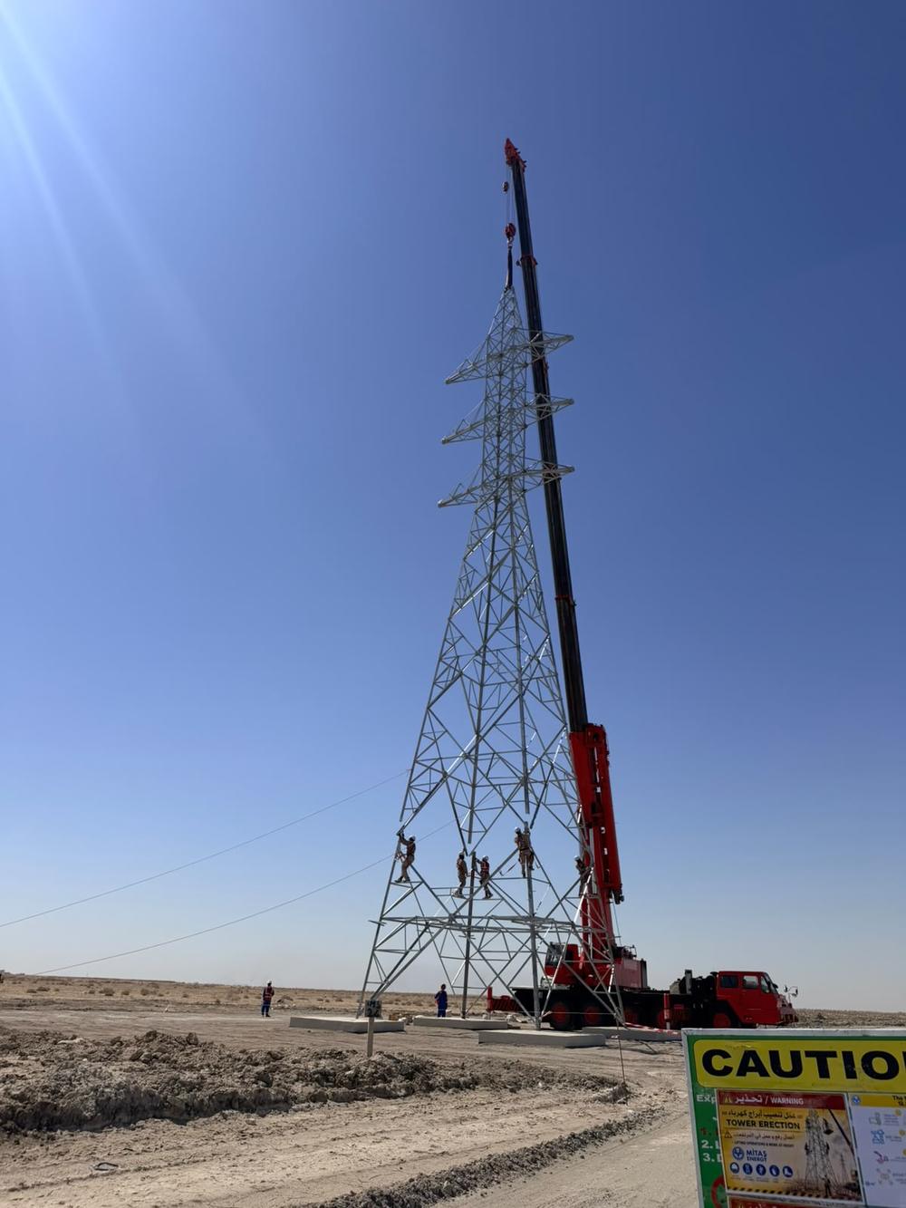 Transmission tower being erected with a mobile crane
